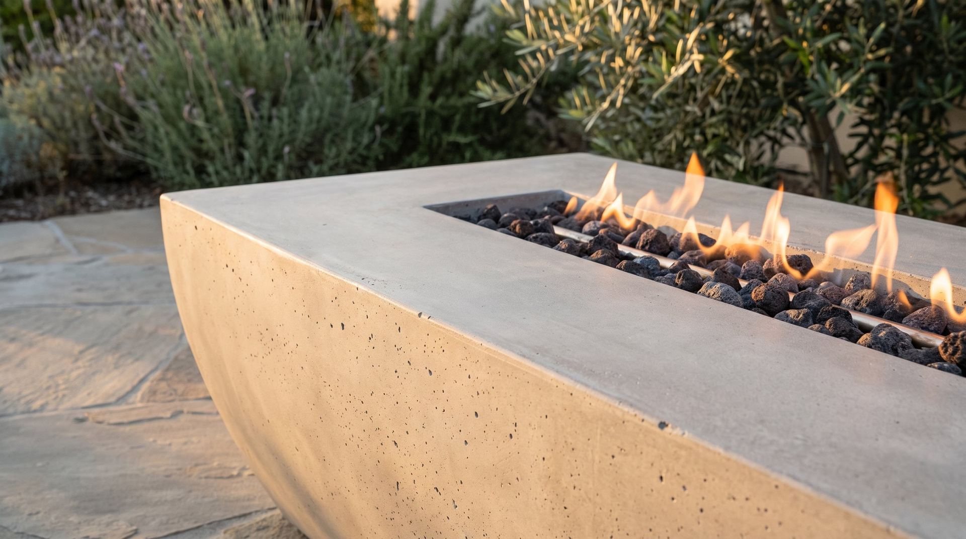 Concrete fire table with flames among olive trees